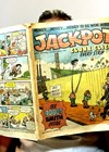 Photo of Peter Cackett reading the Jackpot comic.